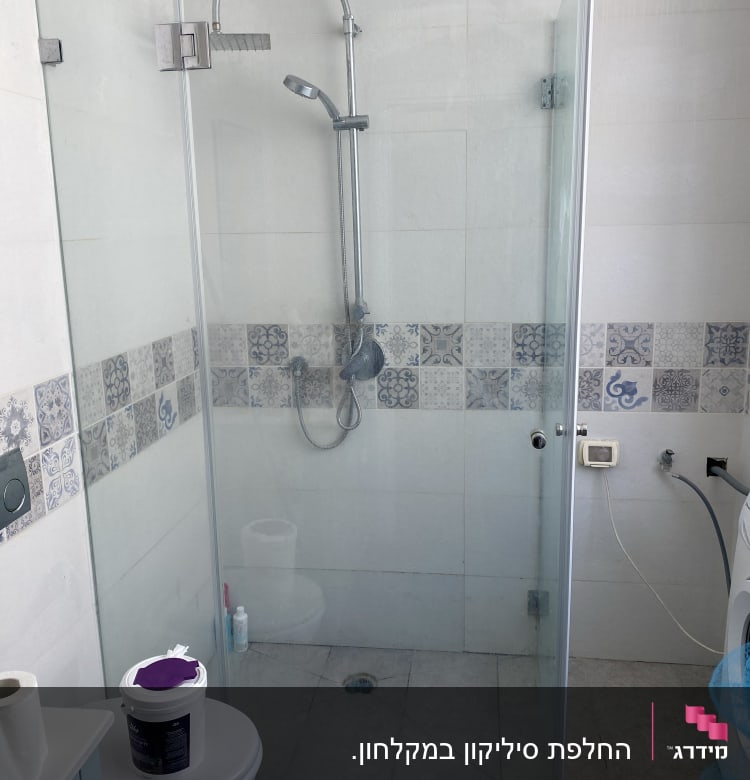 מקלחון זכוכית עם ראש מקלחת מתכתי וקיר אריחים מעוצב